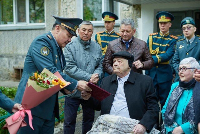 National Guard servicemen congratulate war veteran